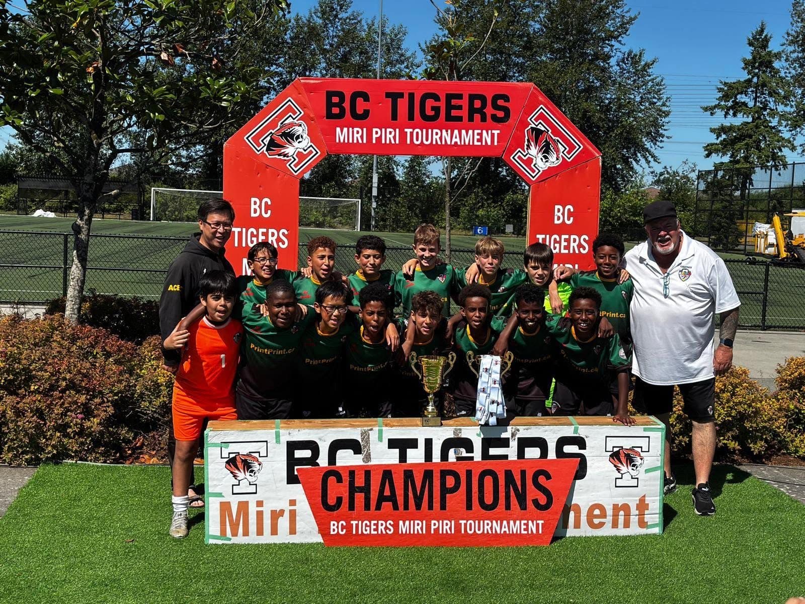 ACBC players with the trophy under the BC Tigers Miri Piri Tournament champions banner